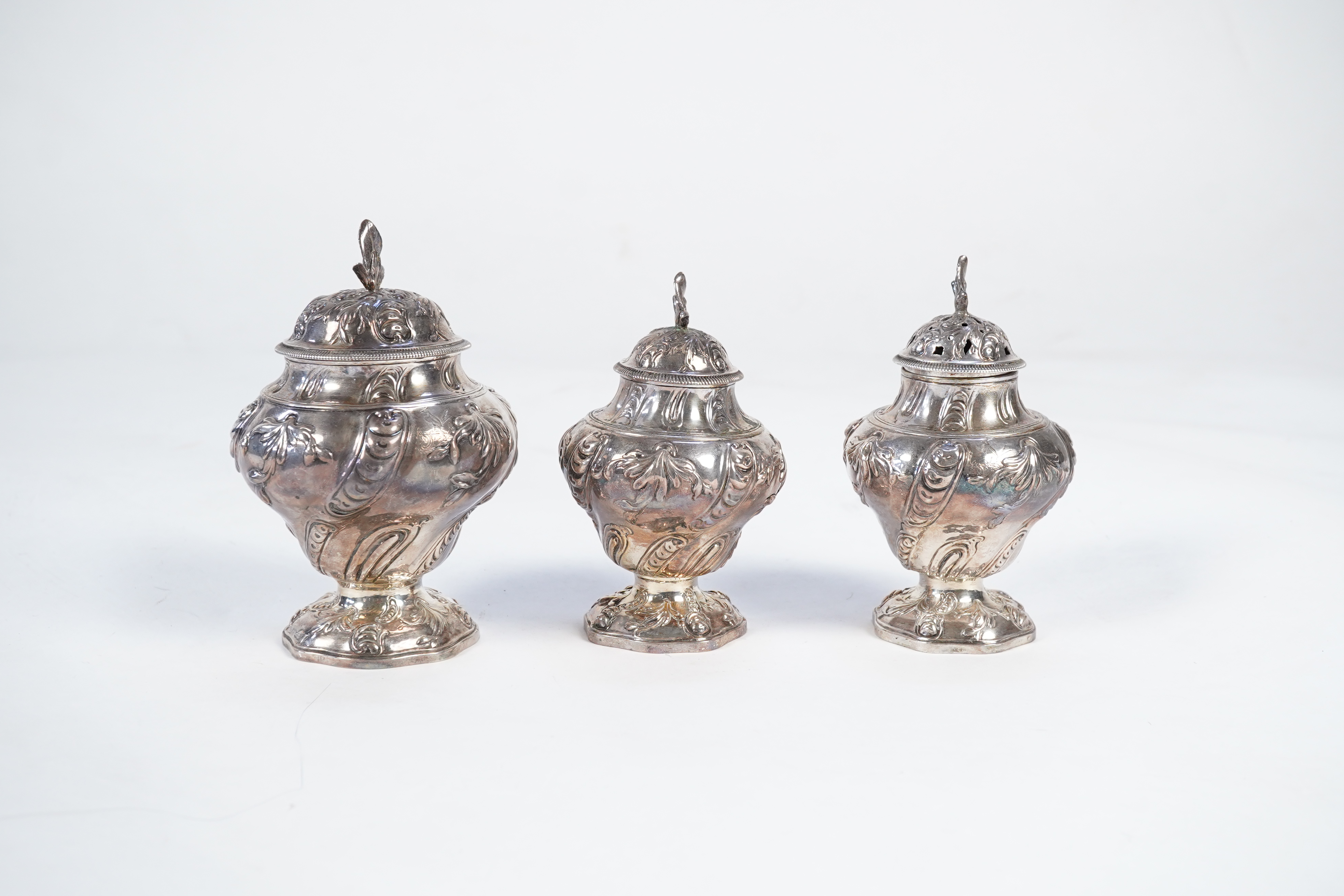 A George II mahogany cased set of two early George III silver tea caddies and covers and a sugar vase and cover, by Samuel Herbert & Co